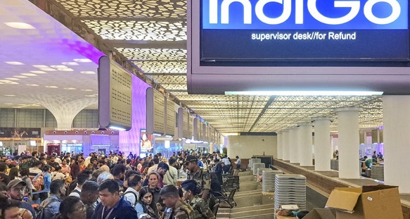 Passengers waiting at airport amid IndiGo flight cancellations across Bengaluru and other cities.